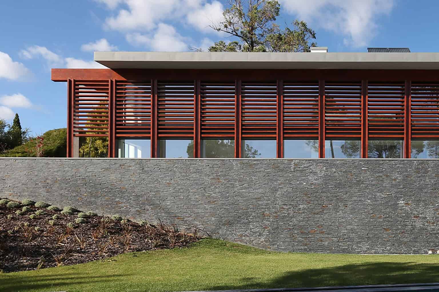 Contemporary villa at Quinta Patino featuring sleek architecture, large glass windows, and natural s.