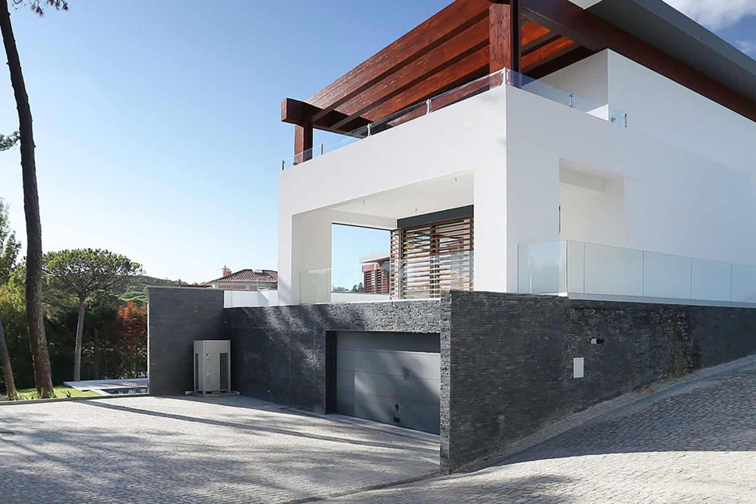 Contemporary villa with sleek white walls, wooden pergola, and spacious garage, located in Quinta Pa.