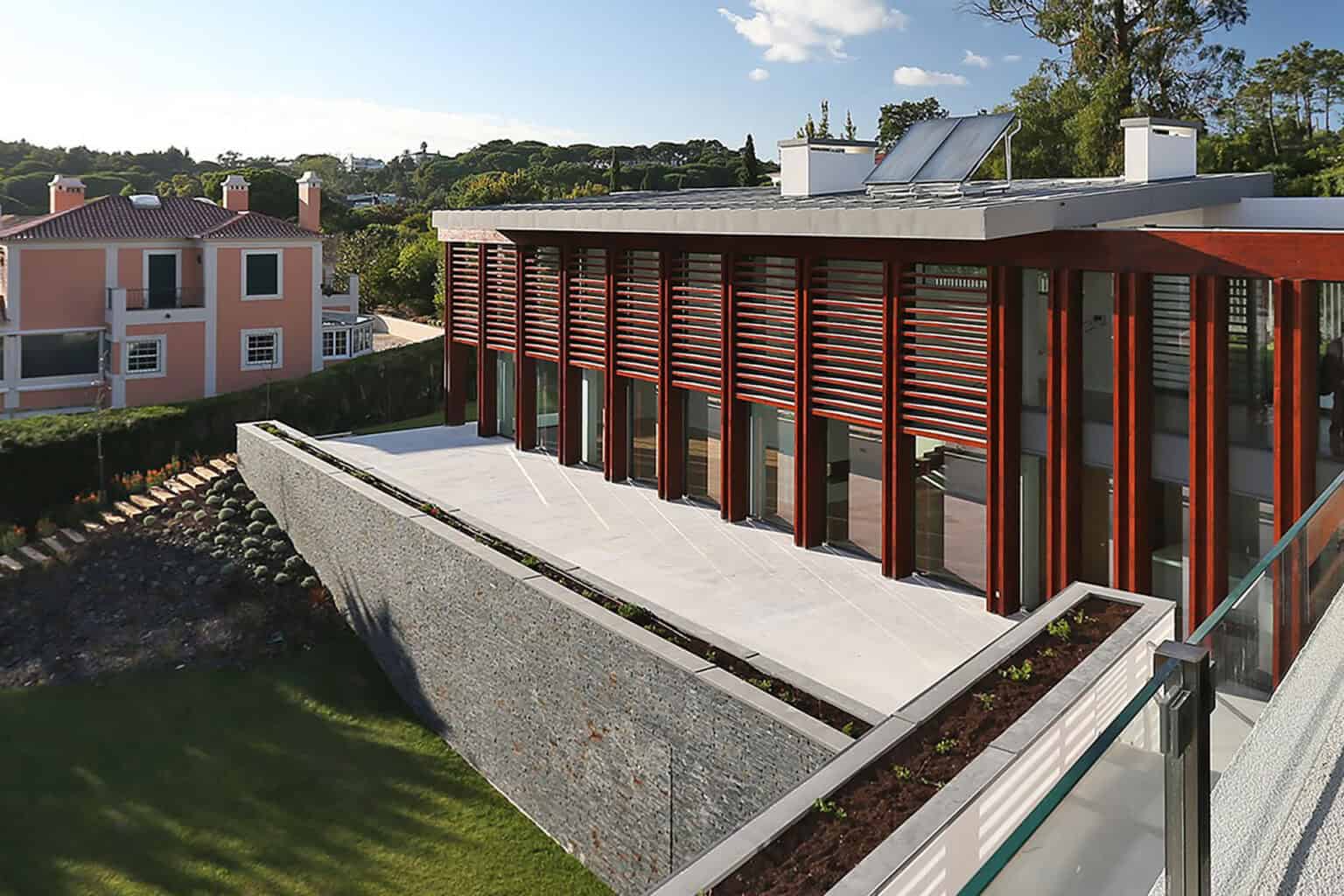 Modern villa with large glass windows and wooden accents at Quinta Patino, offering luxurious living.