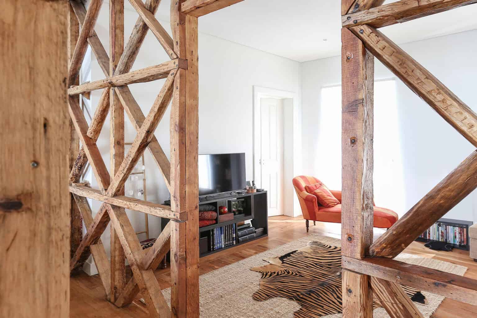 Rustic living room with wooden beams, TV, and comfortable seating.