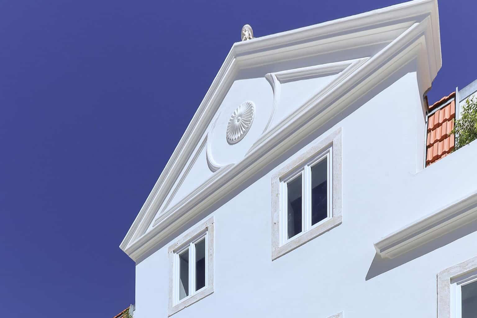 Elegant white residential villa with classic architectural details.