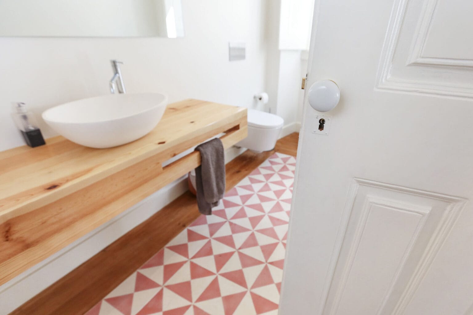 Bright bathroom with modern sink and patterned floor tiles in Ajuda residence.